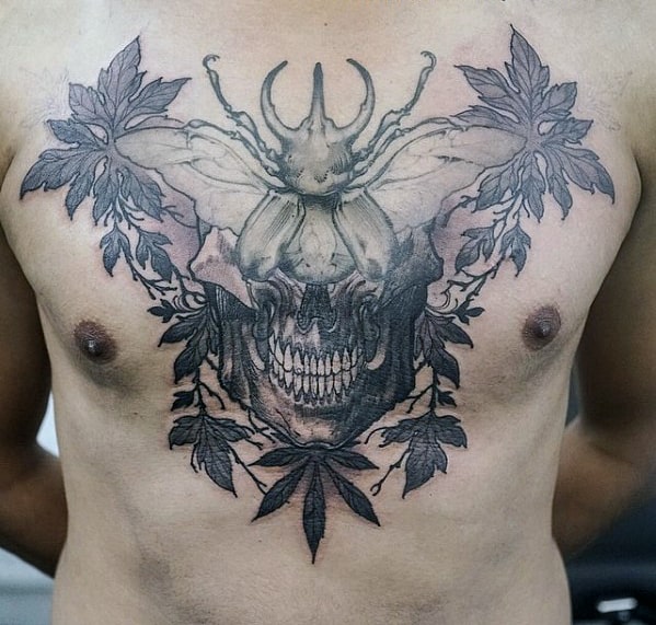 mens skull with scarab and leaves upper chest tattoo