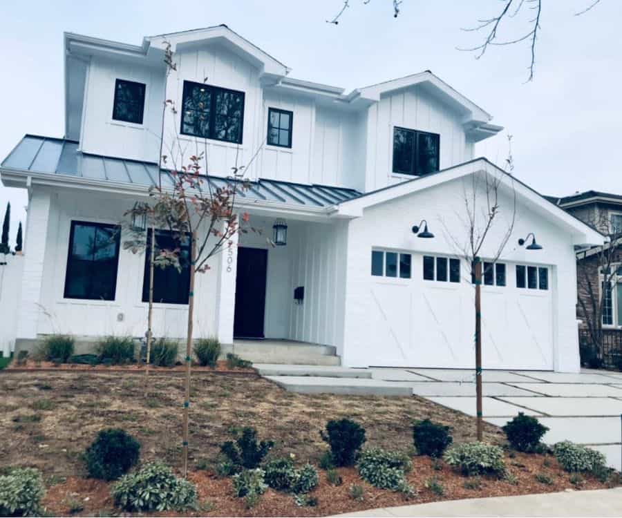 large two story white exterior home with metal roofing 