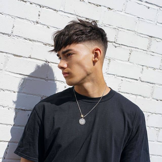 A mid-haircut with forward-swept fringe and medium faded sides and back
