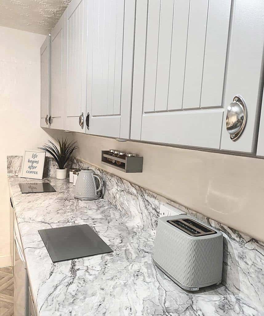 minimalist galley kitchen gray cabinets marble countertop toaster and kettle