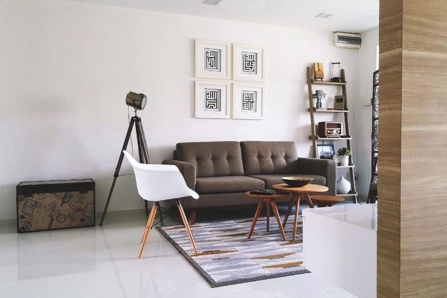 minimalist apartment living room with brown sofa and white accent chair 