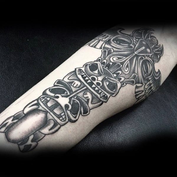 Mischievous Totem Pole In Dark Ink Forearm Tattoo On Gentleman