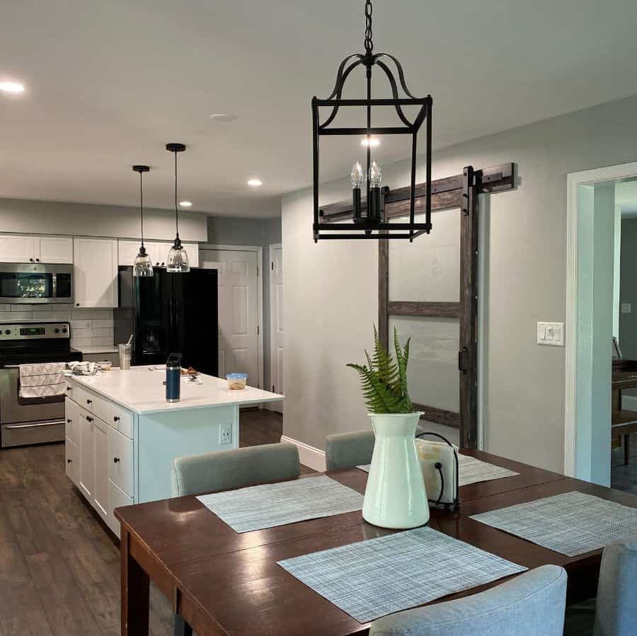 modern open kitchen dining room white island with draws black pendant lights