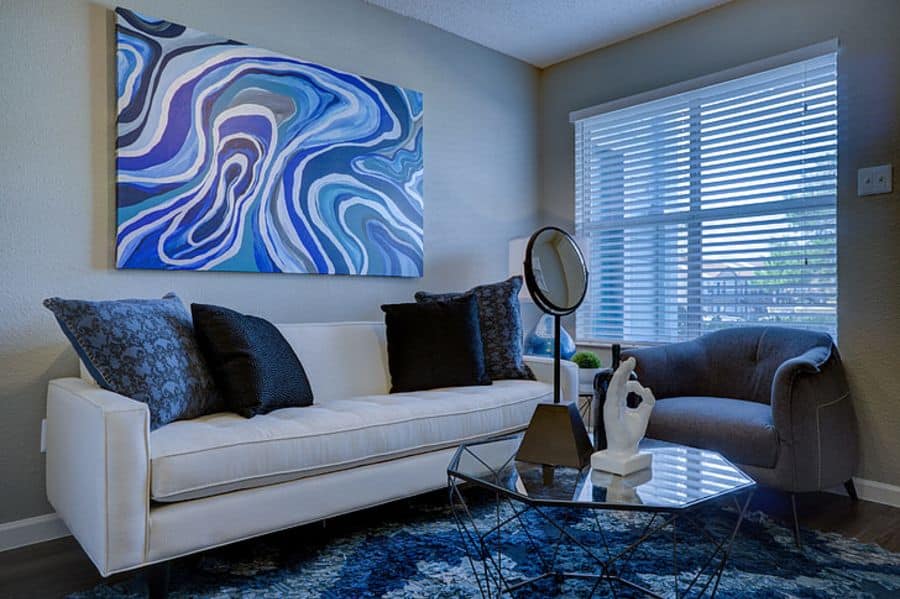 small modern living with white sofa and abstract blue artwork 