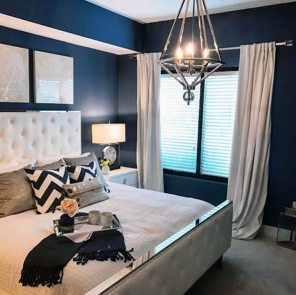 painted blu wall small master bedroom with chandelier