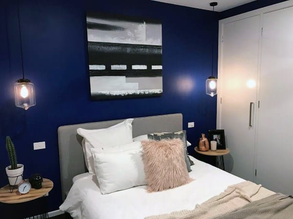 blue accent wall bedroom with white cabinet