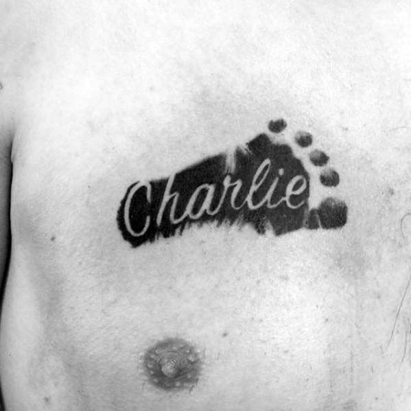 negative space kids name charlie footprint mens chest tattoo