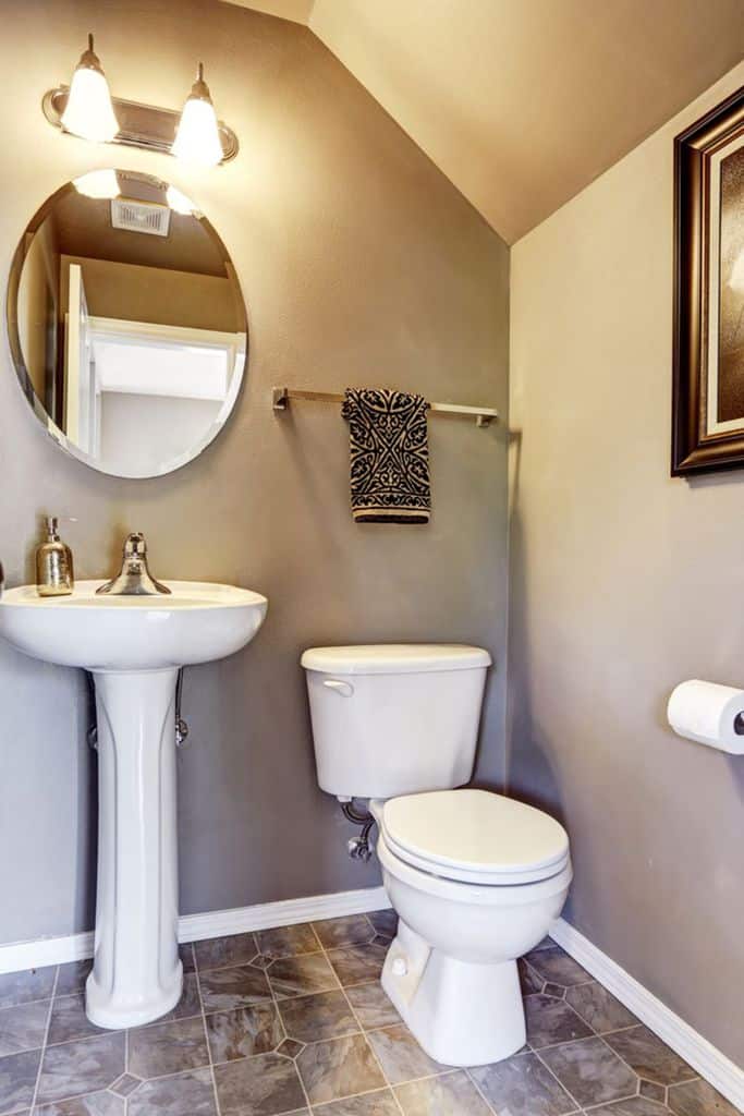 neutral small bathroom with circular wall mirror 