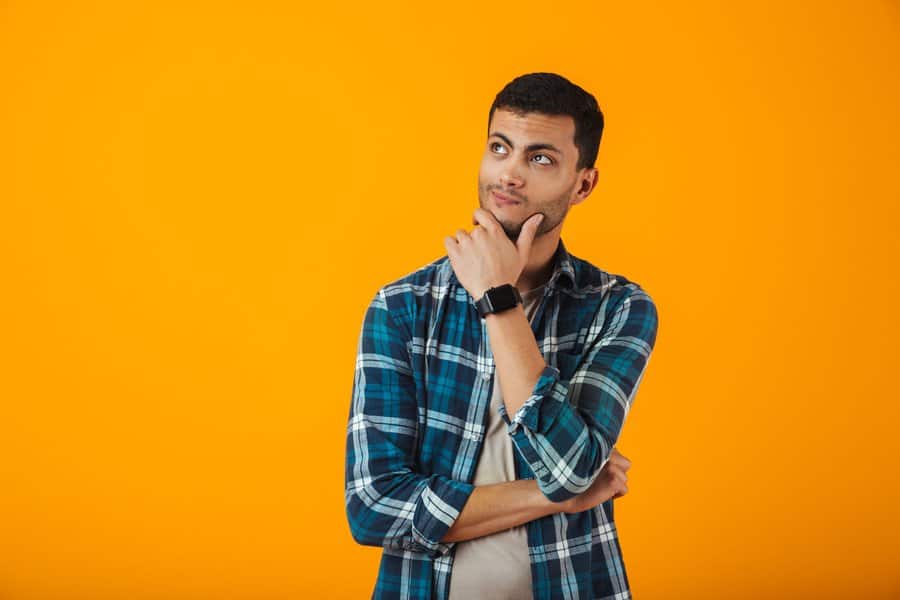 Smiling,Young,Man,Wearing,Plaid,Shirt,Standing,Isolated,Over,Orange