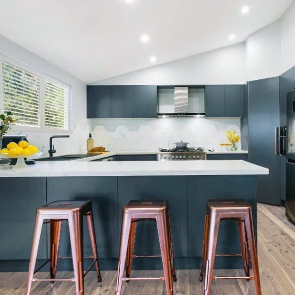modern kitchen with nay blue cabinets and copper stools bench seating 