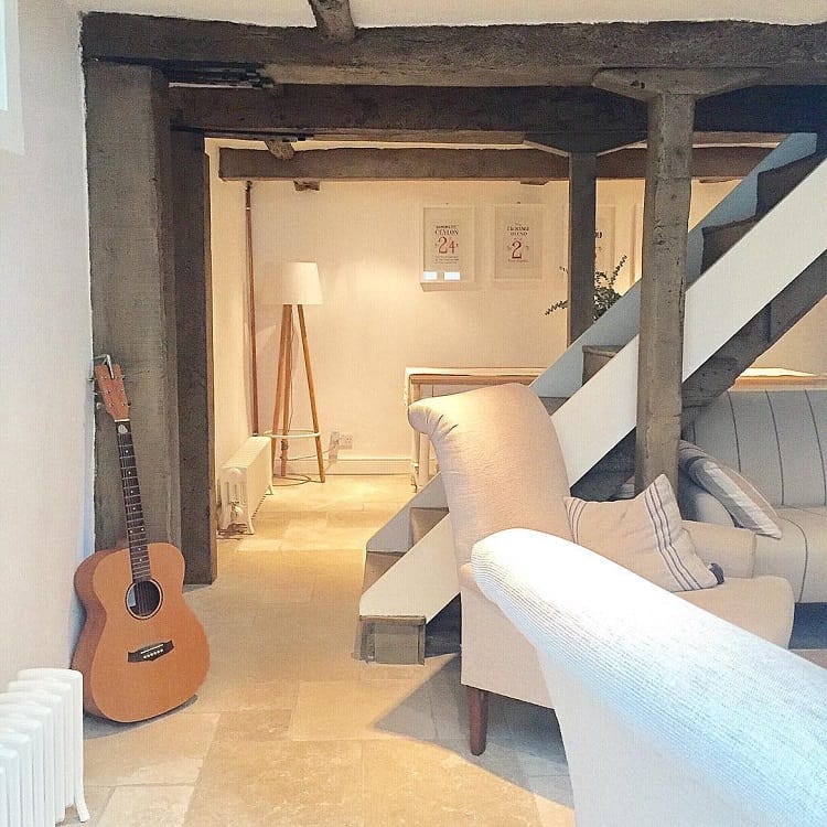 oak beam basement beige sofa acoustic guitar 