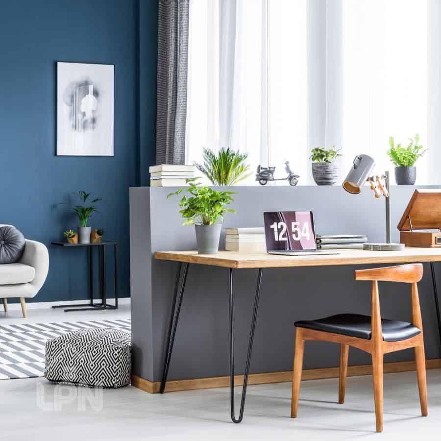 small office space home living room wood desk and chair small plants blue accent wall