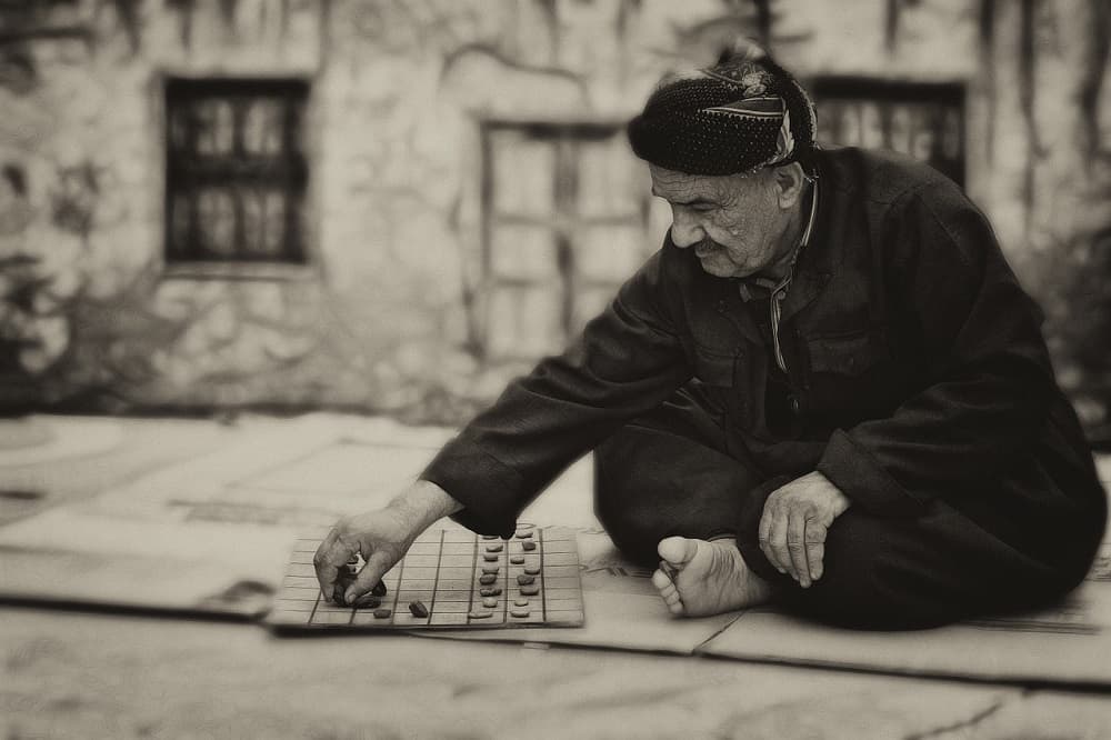 an old man playing board game outdoor