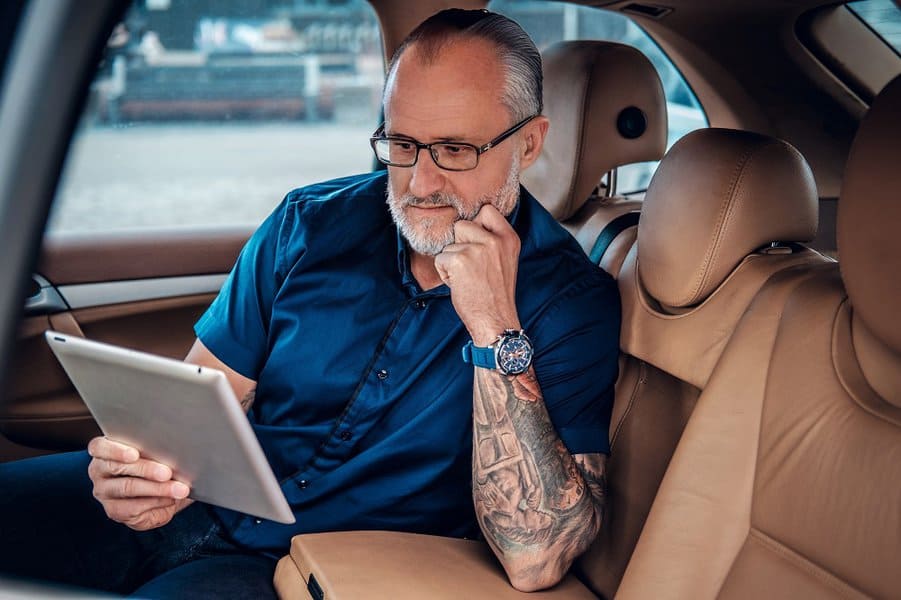  old man with tattoo and glasses using tablet