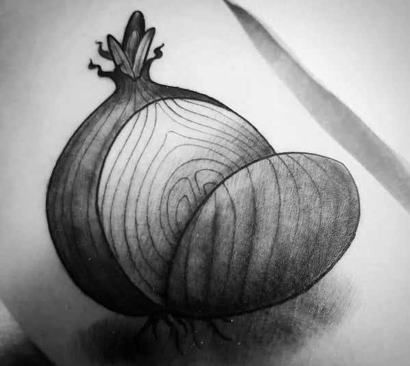 Realistic black and grey onion tattoo featuring fine line details, intricate shading, and a sliced section to highlight natural texture and depth.