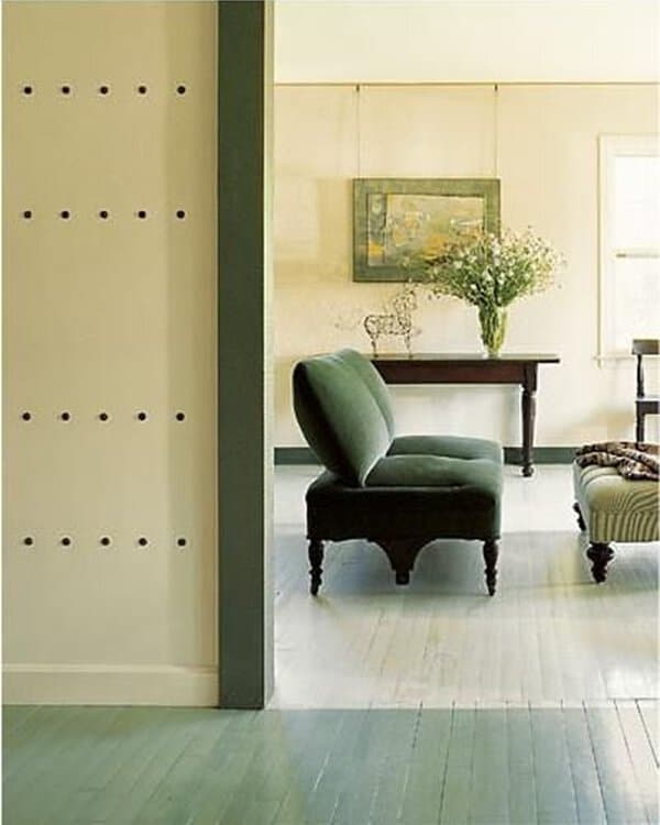 Living area with half-green, half-light painted wood floor, green seating, and simple decor for a calm, two-tone look.