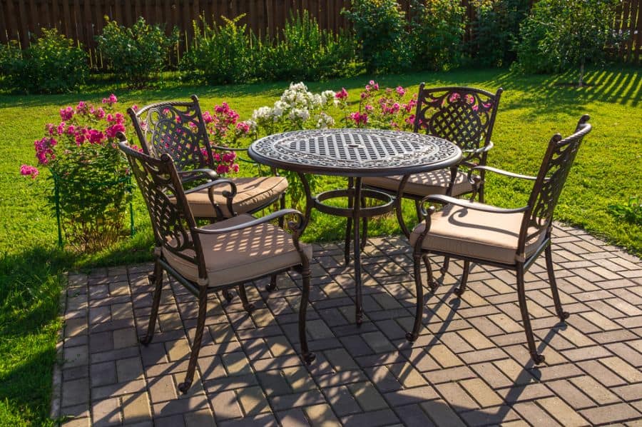 ornate metal table and chairs on brick paver patio 