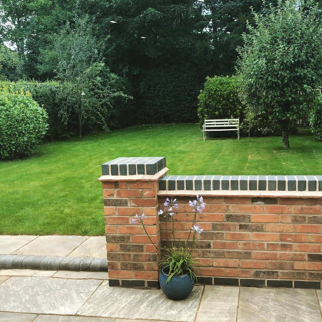 brick wall large grass garden park bench paver patio