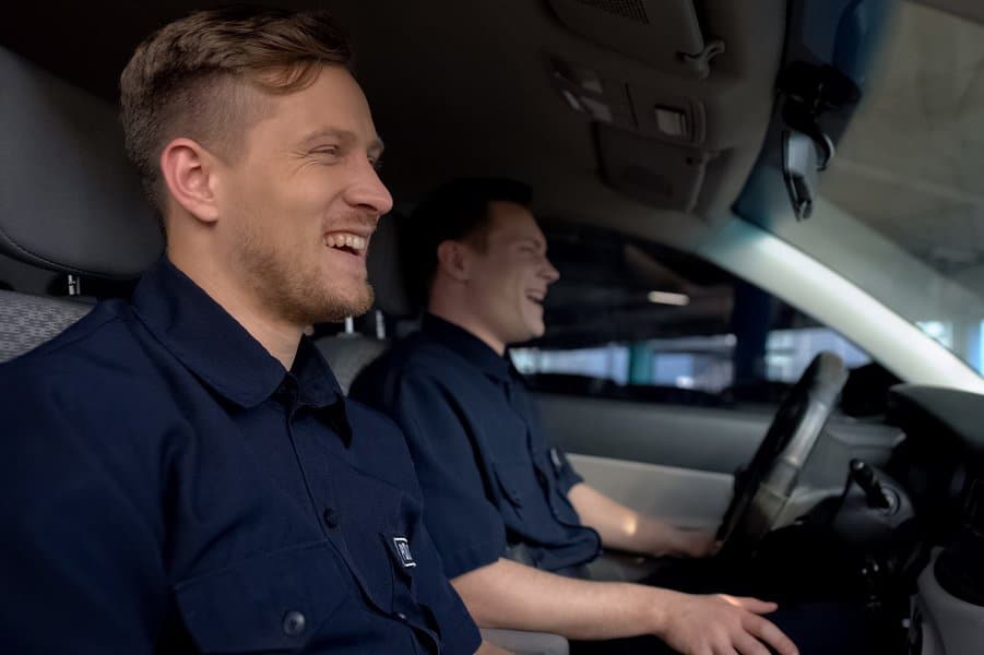 police mates laughing in patrol car