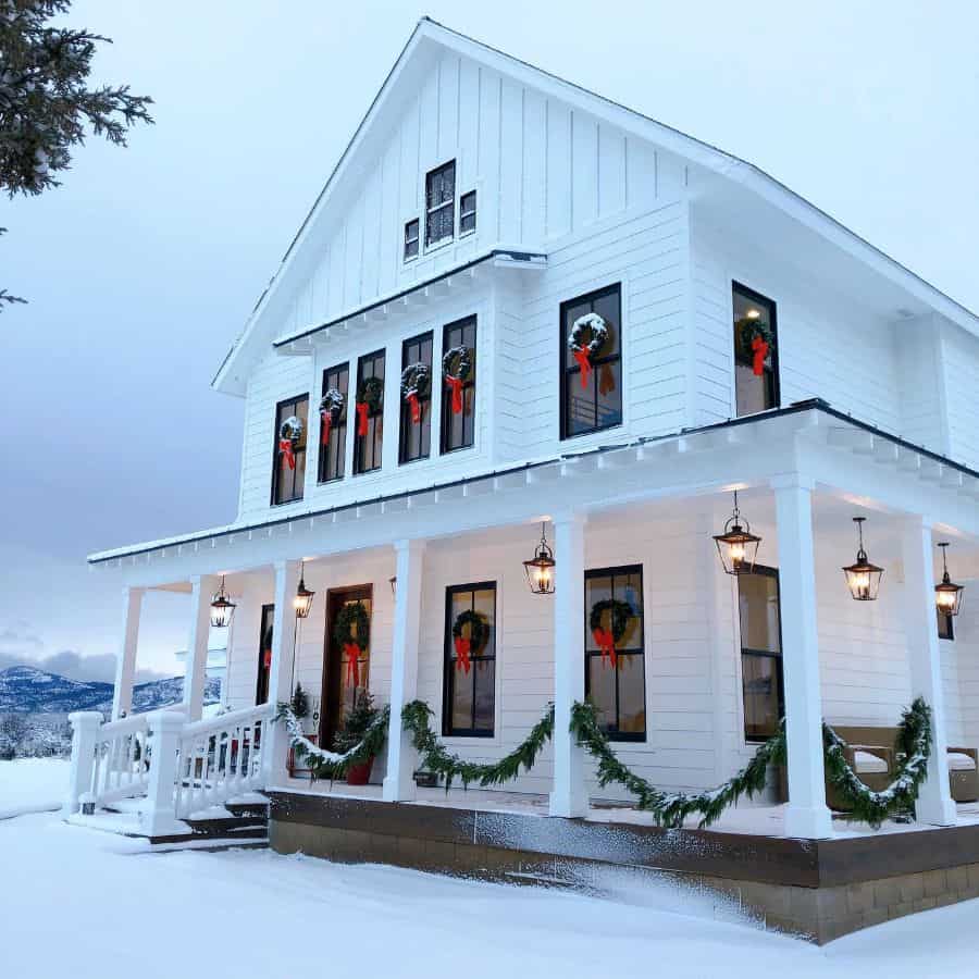 wraparound porch on white home during christmas 