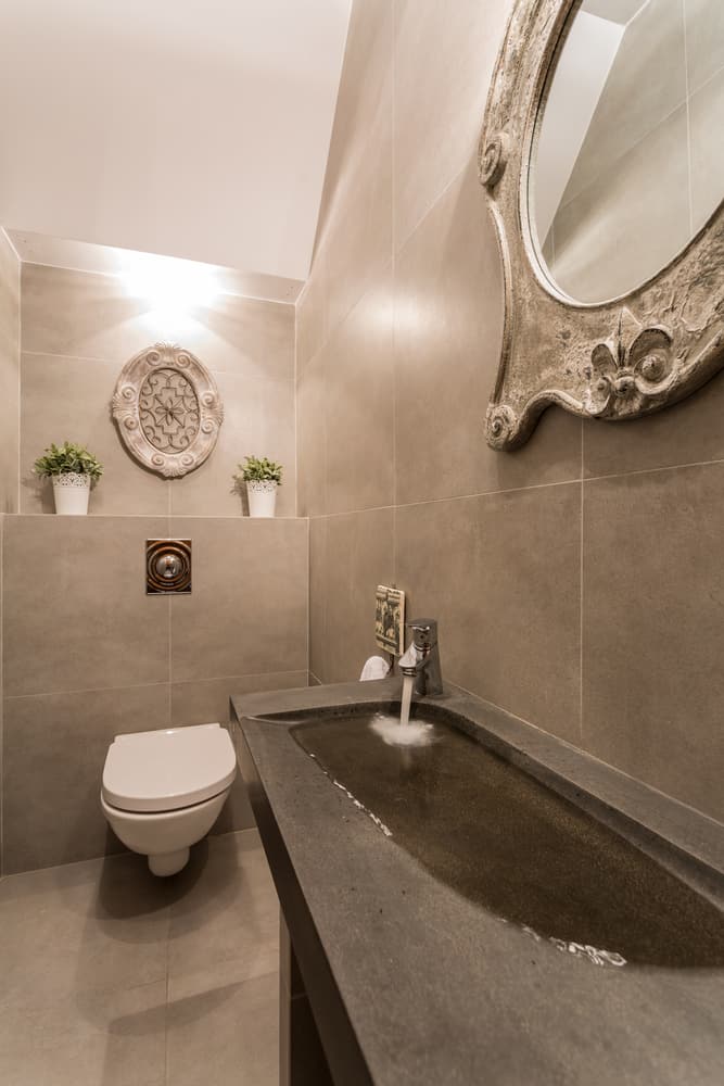 luxury powder room gray tiles large sink ornate mirror 