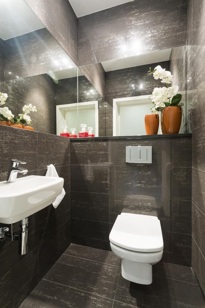 glossy gray tile half bathroom with wall mirrors 