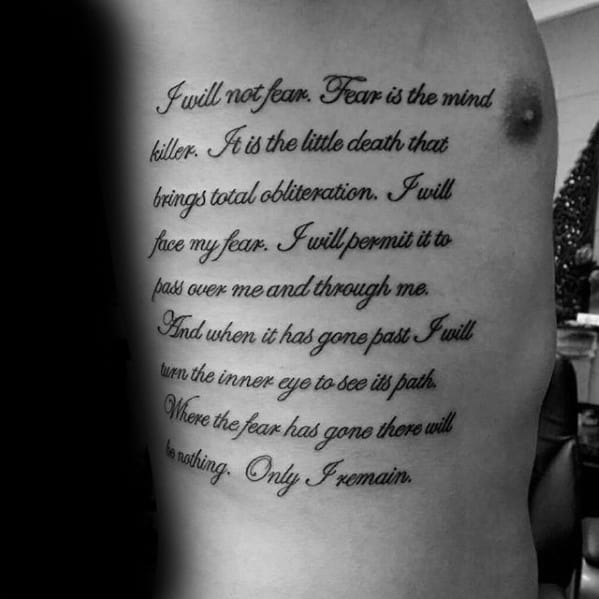 Rib writing tattoo with I will not fear quote by Frank Herbert on side of man's ribs