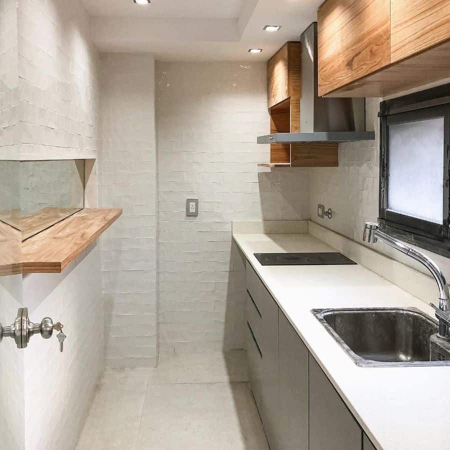 recessed lighting in small kitchen white painted brick wall 