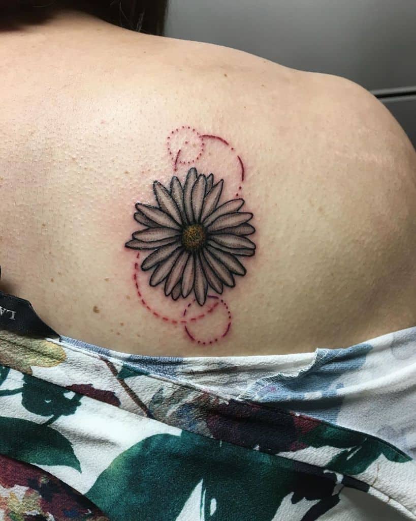 Shoulder blade tattoo color geometric concentric red circles white and yellow daisy