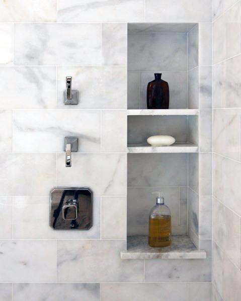 Marble shower with built-in niches for toiletries and polished chrome fixtures.