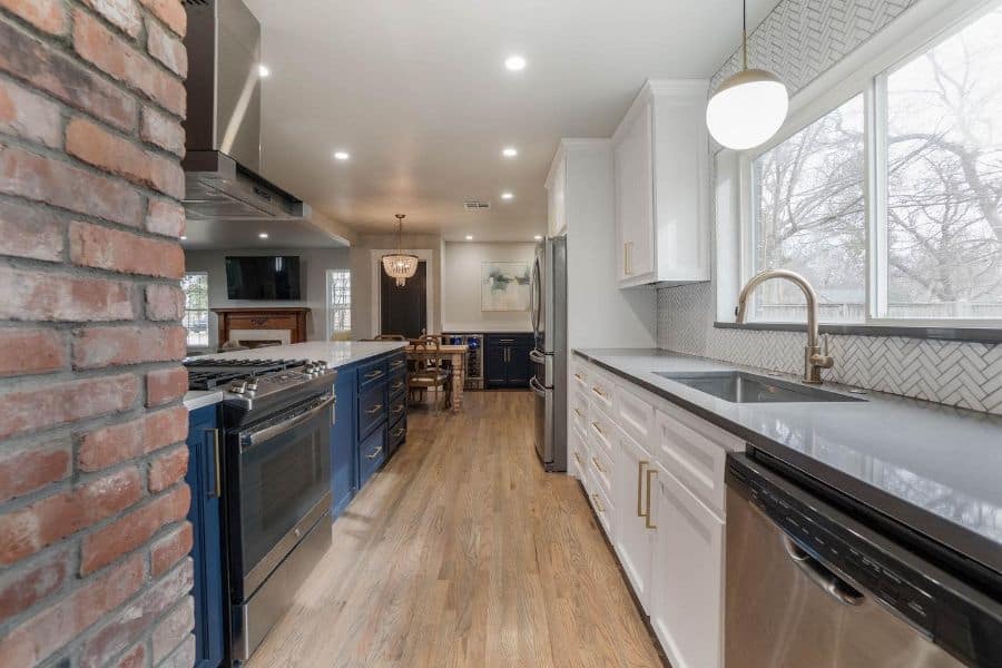 remodel galley kitchen white and blue cabinets brick wall chandelier