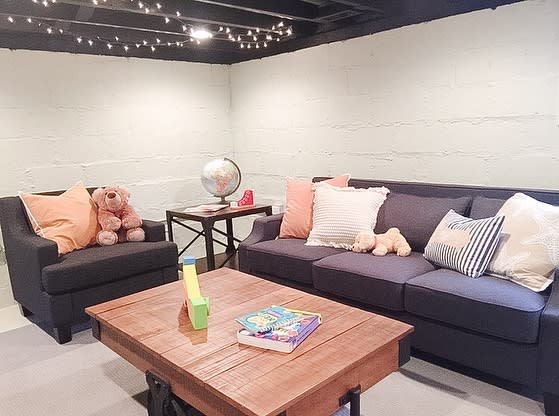 small basement living room with sofa and wood coffee table 