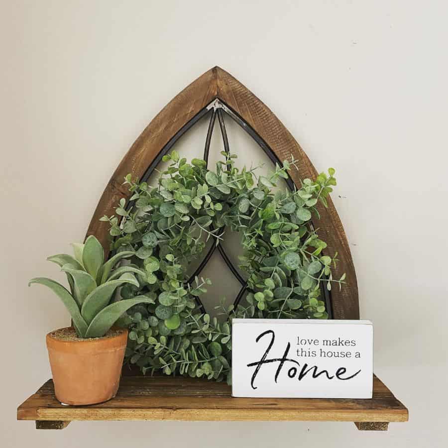 wood wall shelf with plants and sign 