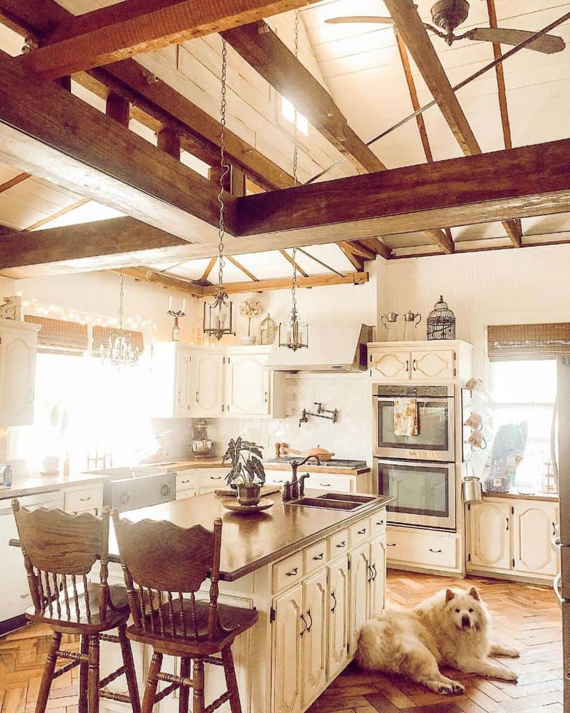 rustic farmhouse kitchen with white cabinets and exposed wood beam ceiling 