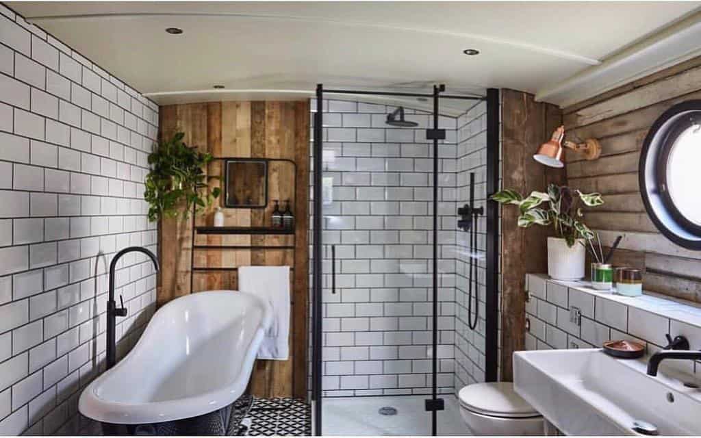 luxury modern bathroom with white tile and wood panel accents and full shower and bath in boat 