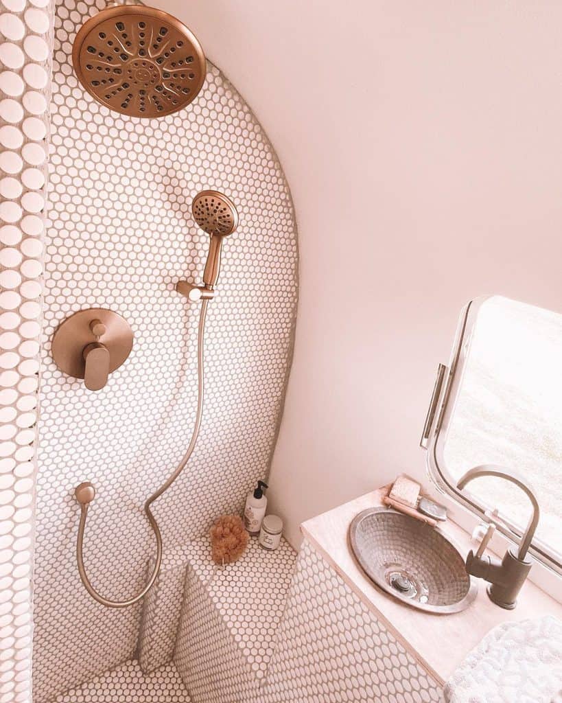 pink tile bathroom with shower and bronze accents 