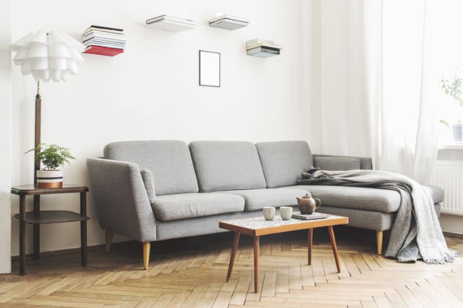 scandinavian small living room with gray sofa and book wall artwork 