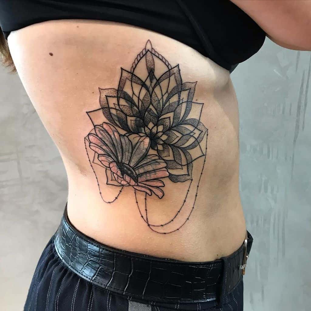 Rib tattoo black and grey stipple shading ornamental mandala daisy