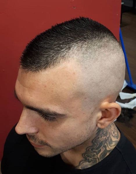 A Mohawk featuring short hair on top and tapered sides for a punky look