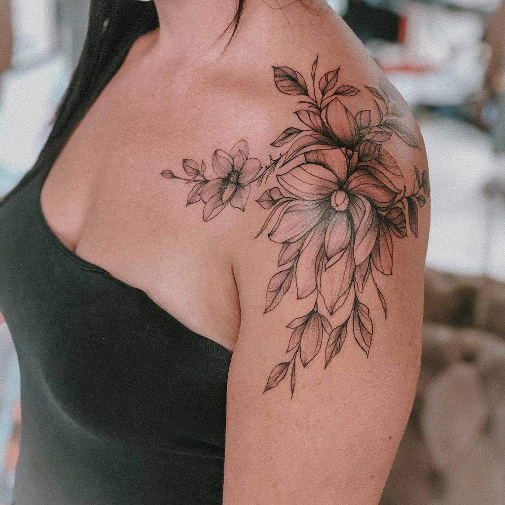 Couple of magnolia flowers tattooed on the upper arm