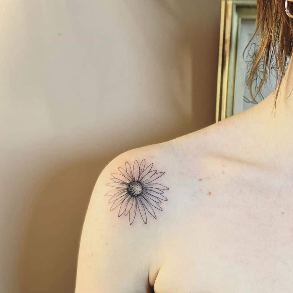 Female shoulder tattoo black and grey fine line daisy