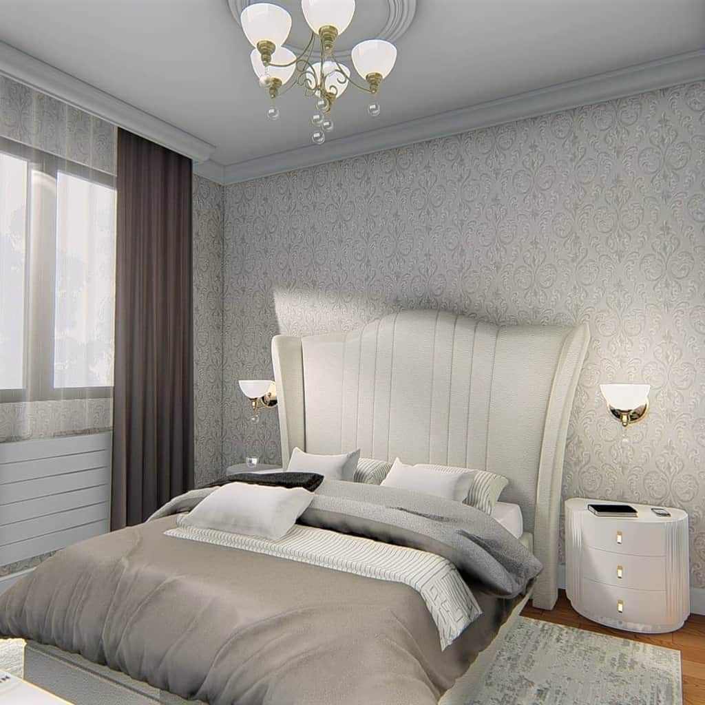 Elegant bedroom with patterned wallpaper, tufted white bed, and neutral bedding.