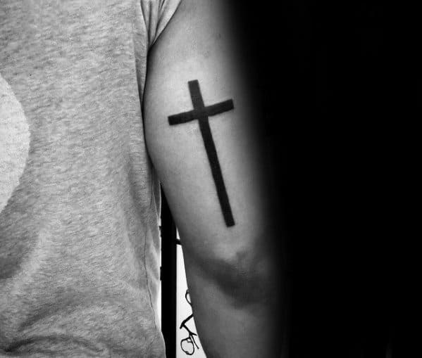 Simple Black Ink Cross Back Of Arm Tattoo On Man
