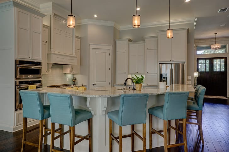large farmhouse kitchen white cabinets blue chairs pendant lights