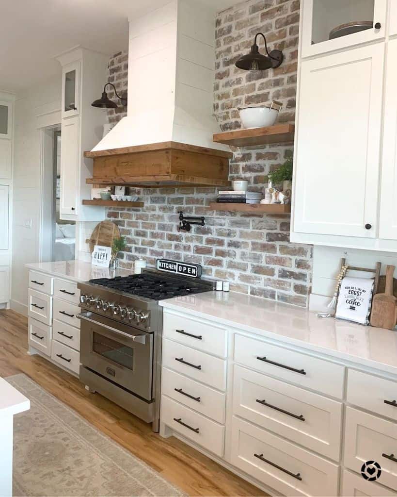 simple farmhouse kitchen brick splashback white cabinets silver stove and oven