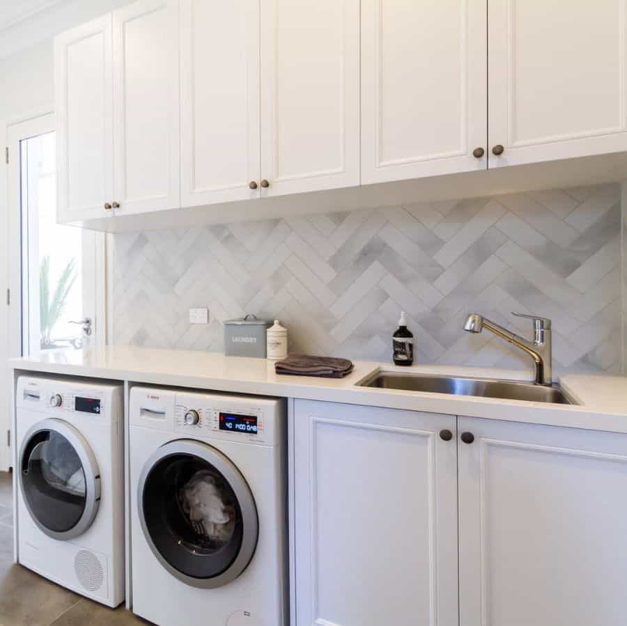 simple white cabinet laundry room with sink