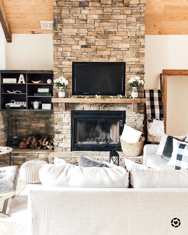 simple living room stone fireplace wall mounted tv white sofa wall shelves 