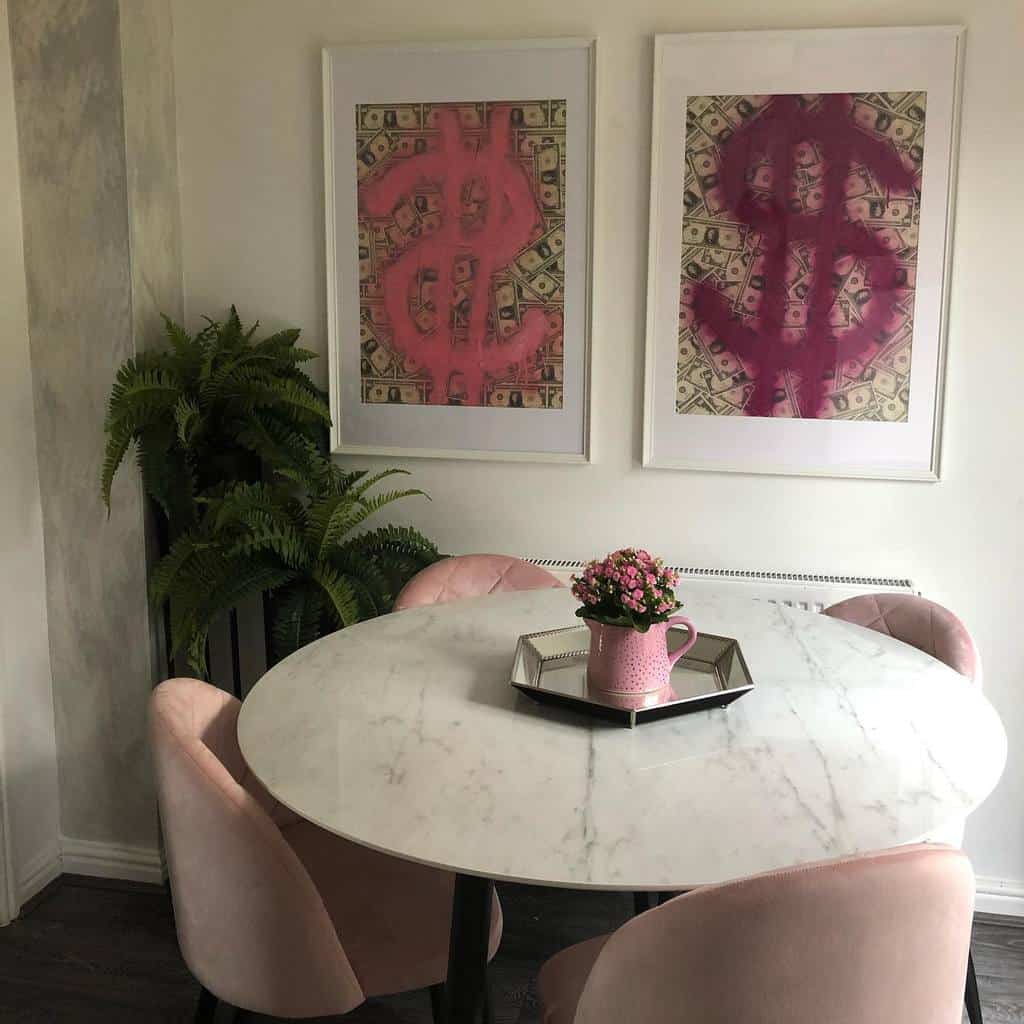 marble dining table with pink chairs and pop art wall decor 