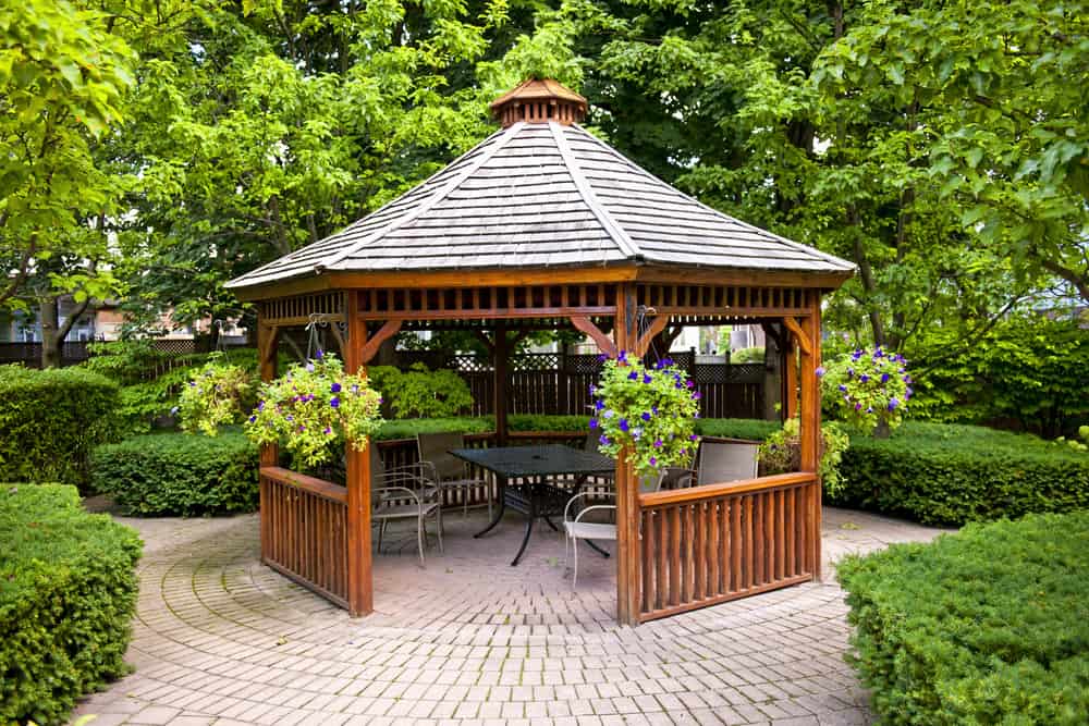small stained wood gazebo paved floor outdoor table and chairs 