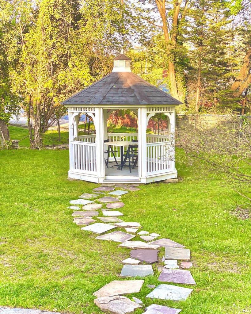 small white wood gazebo table and chairs stone pathway 